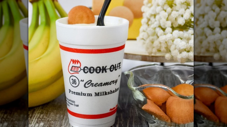Cook Out banana pudding milkshake with bananas and Nilla Wafers on a table