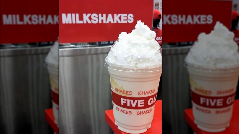 A Five Guys milkshake on the counter with whipped cream