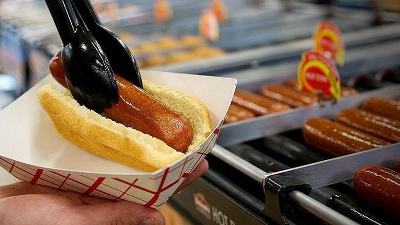 A person puts a wiener in a bun at a Love's Travel Stop