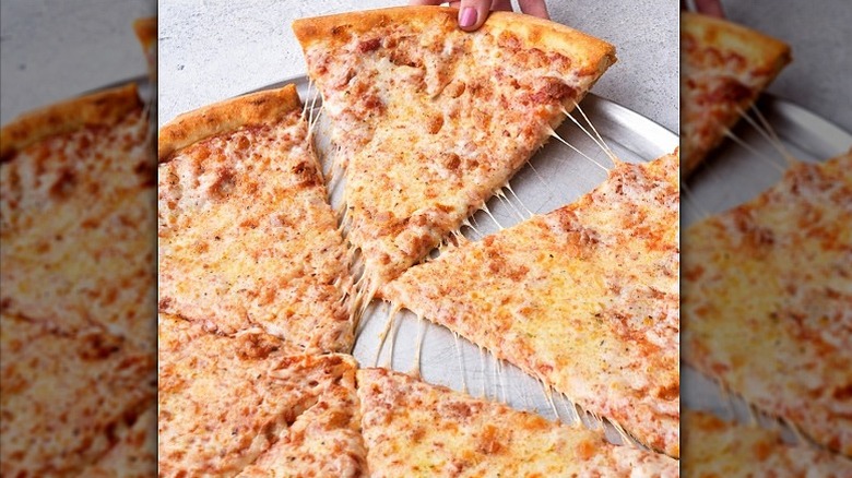 Closeup of a cheese pizza piece being pulled away from the pie at Sbarro