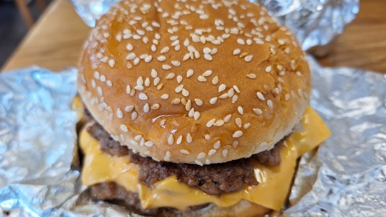 A double cheeseburger at Five Guys rests on an aluminum wrapper