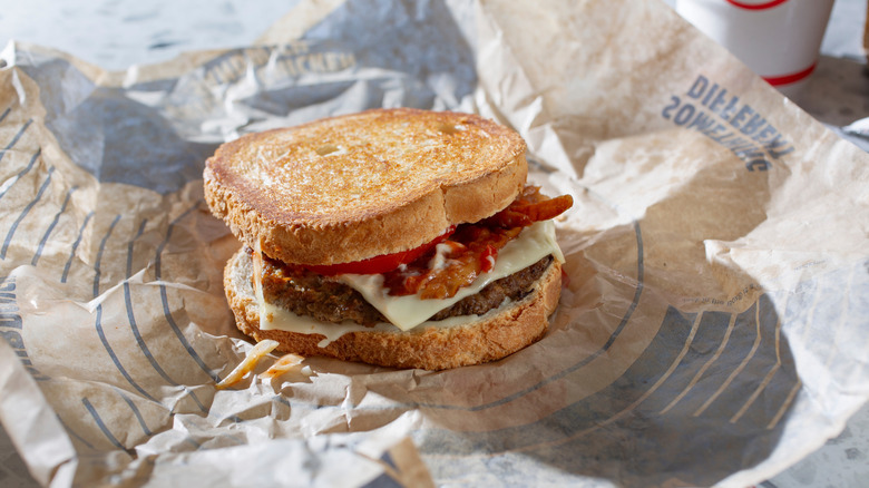 A sourdough burger at Jack in the Box sits on a paper wrapper