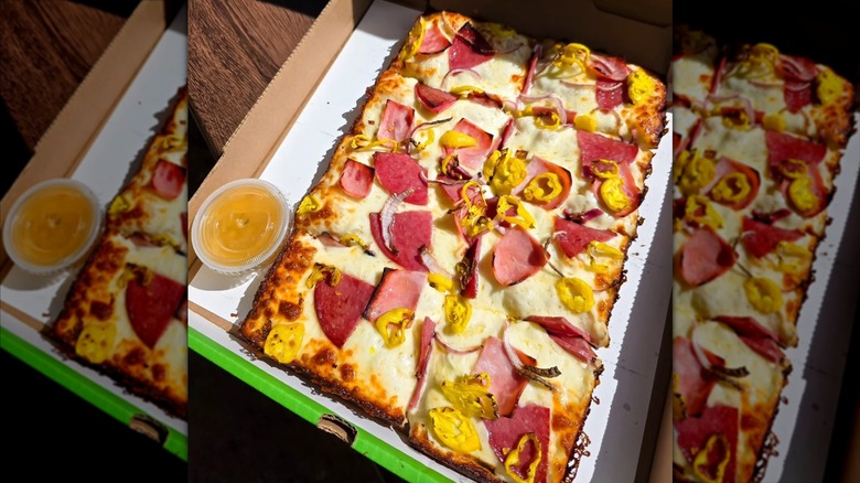 Detroit-style pizza in a cardboard pizza box.