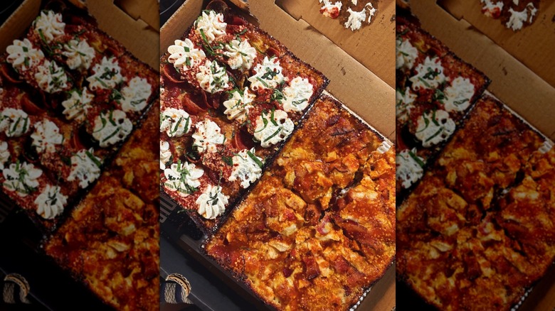 Two Detroit-style pizzas in a cardboard box.