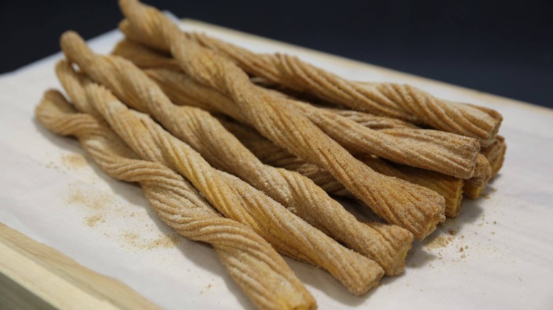 Churros sit on parchment paper