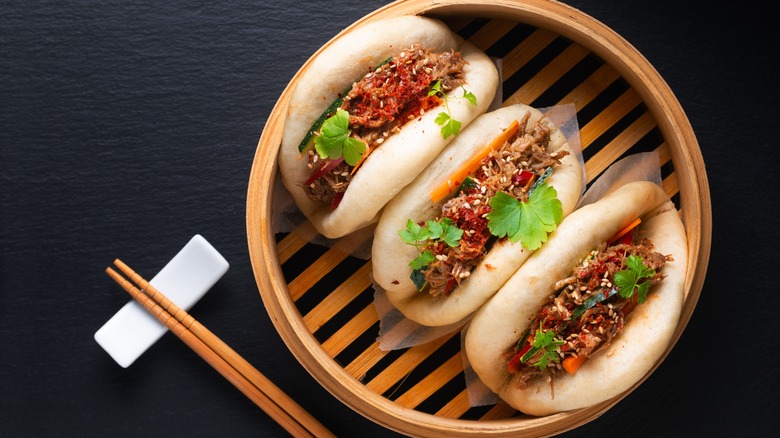 three bao buns neatly displayed on bamboo steamer