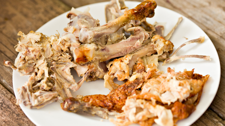 leftover bones from a rotisserie chicken on a plate