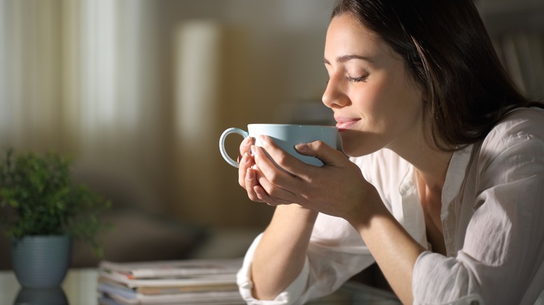 Woman smelling coffee