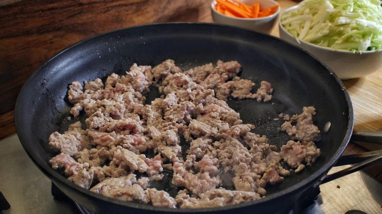 ground pork cooking in skillet