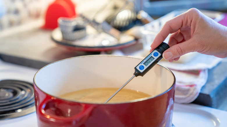 Checking the temperature of oil for deep frying with a probe thermometer