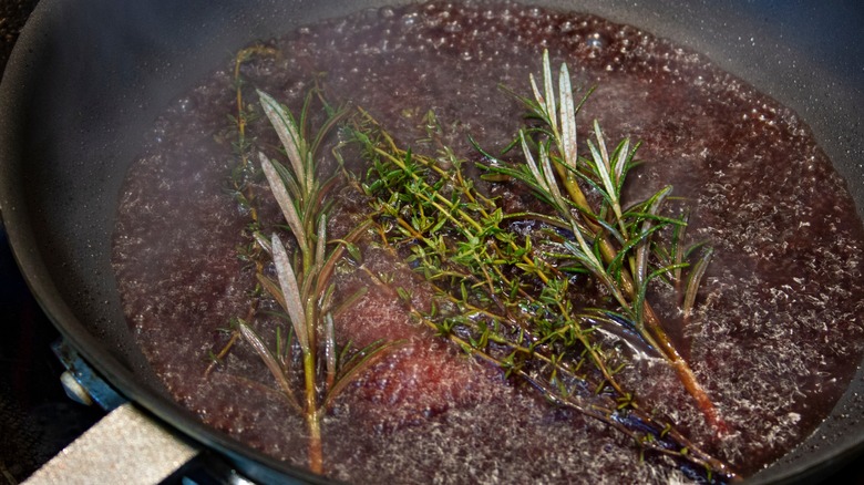 Deglazing in pan with thyme and rosemary