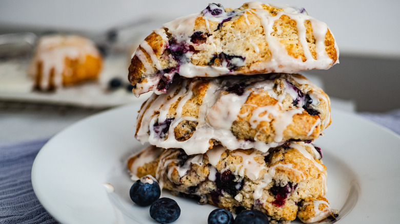 Berry studded breakfast biscuits stacked on a white plate