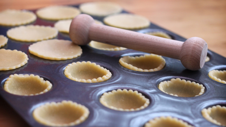 dough pressed into muffin tin