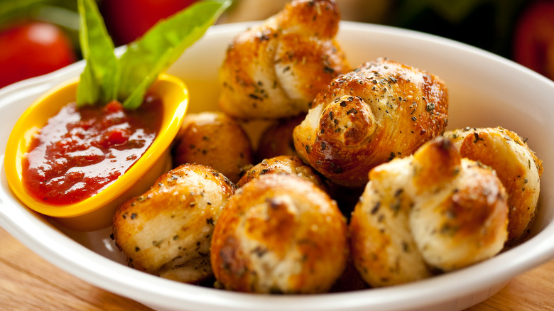 Garlic knots piled in a white bowl