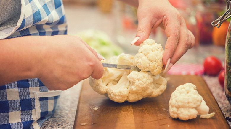 Woman's hands chopping cauliflower