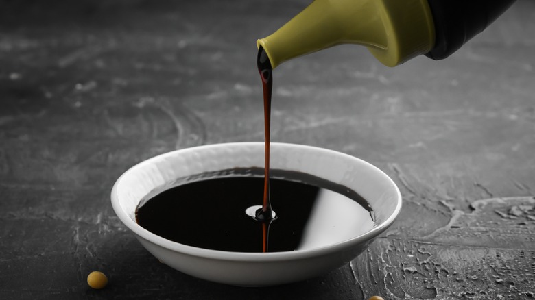 Pouring soy sauce into ramekin 