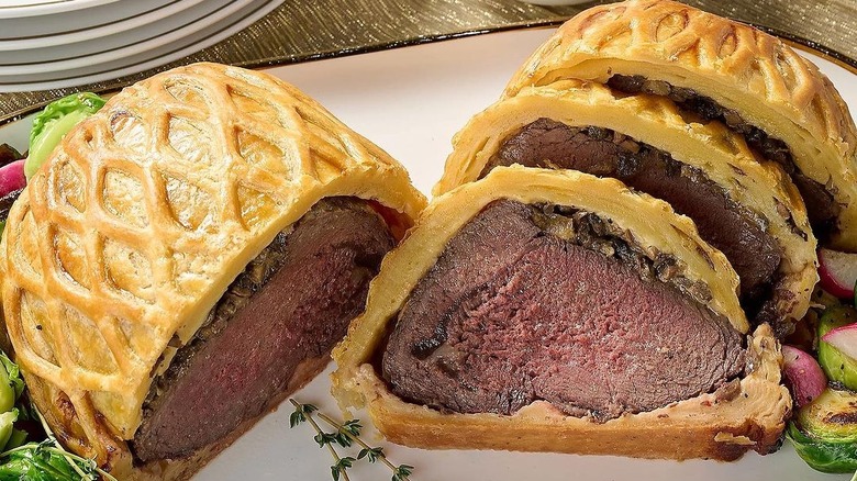 classic beef wellington sliced on plate