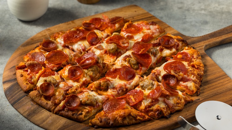 thin crust pizza served on cutting board