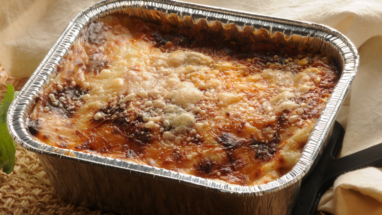 Frozen lasagna in an aluminum container.