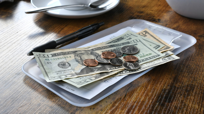 Money in a restaurant tip tray.