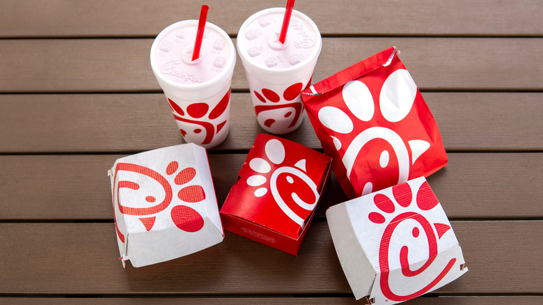 Prepared Chick-Fil-A food and drinks in takeout containers laid out on a table.