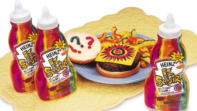 Three bottles of EZ Squirt and a burger and fries with colorful patterns.