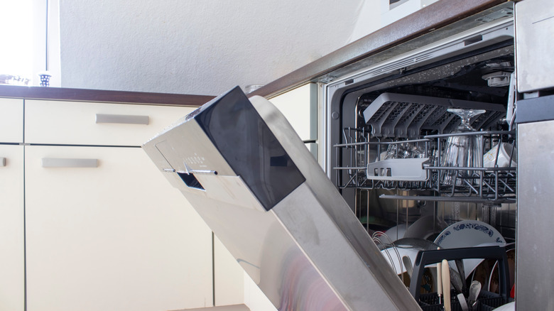 Stainless steel dishwasher with door open showing clean dishes