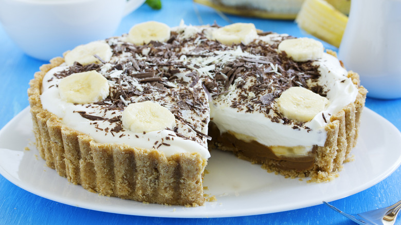Whole banoffee pie on white plate