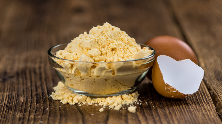 Egg powder and cracked shell on wooden table