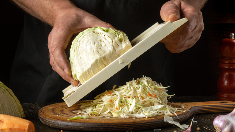 Chef slicing fresh cabbage using a mandoline