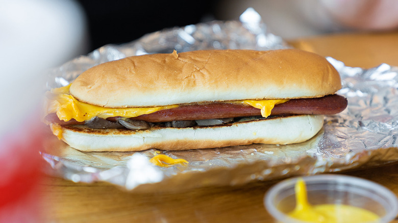 A Five Guys cheese dog sits on its foil wrapper