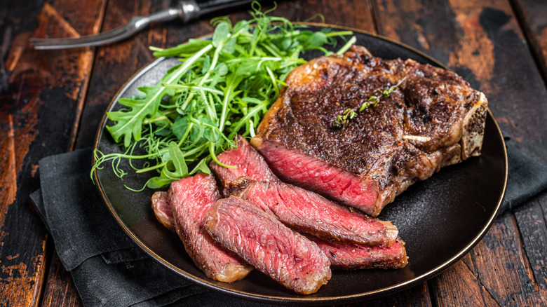 Grilled steak cut medium rare with arugula salad