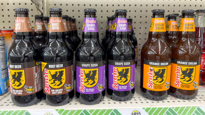 Bottles of Sprecher Root Beer, Orange Dream, and Grape sodas on a Dollar Tree store shelf