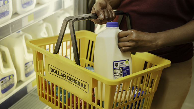 A shopper places a jug of milk in a Dollar General shopping basket