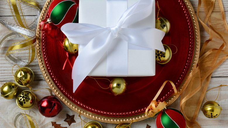 Decorative Christmas items sit atop a red charger plate and a gold charger plate
