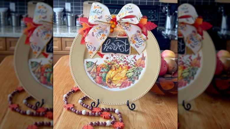 A fall decoration created using the gold plastic charger plate with beaded rims from Dollar Tree