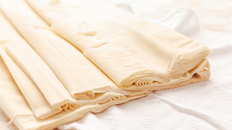 Raw puff pastry on white surface