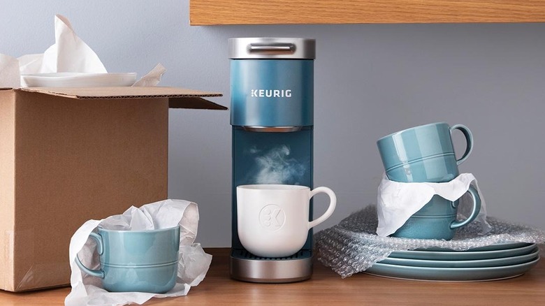 A pretty blue Keurig coffee maker sits on a table