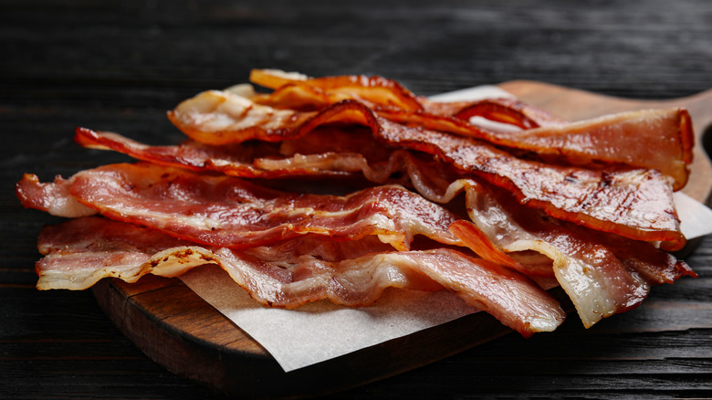 cooked bacon on wooden cutting board