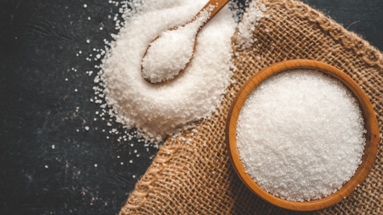 Wooden bowl and spoonful of salt