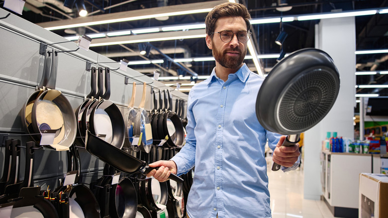 Person buying pans in a store