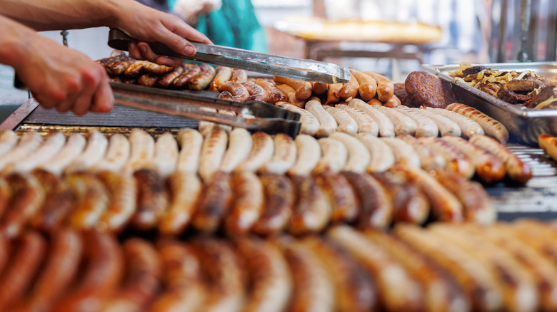 Varieties of sausage being prepared by a vendor
