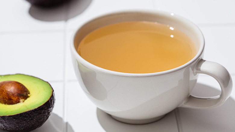 A cup of tea next to avocados