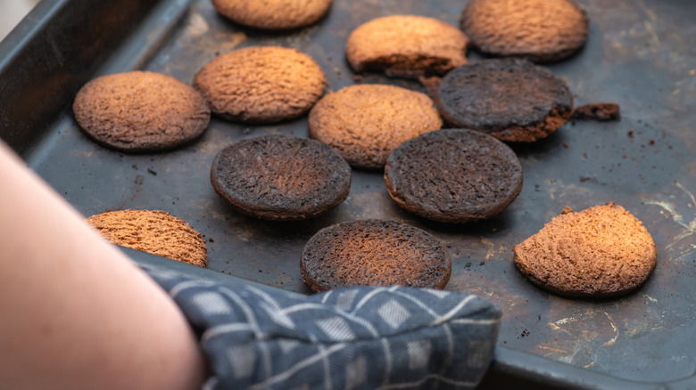 Baker removing a tray of burned cookies