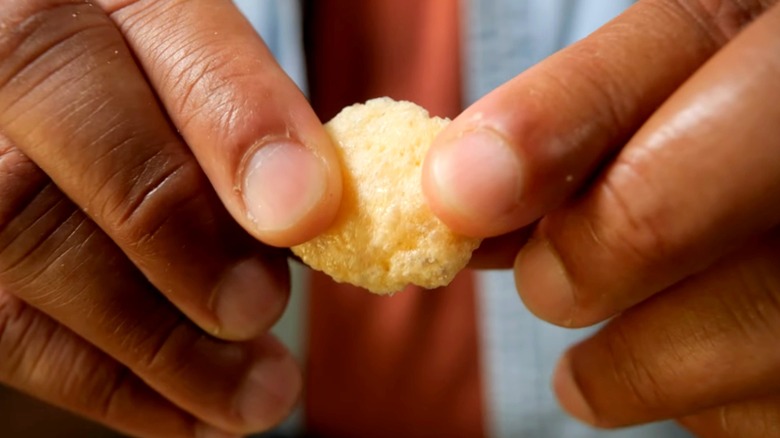 Hands hold a microwaved parmesan rind puff