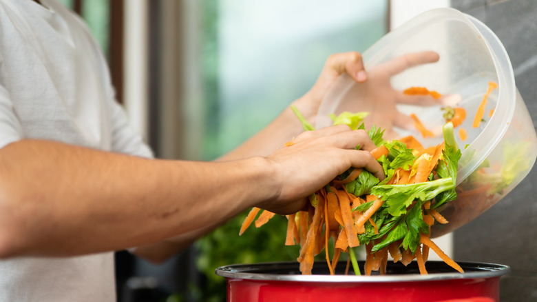 Chef dumping vegetable scraps into a pot to make stock
