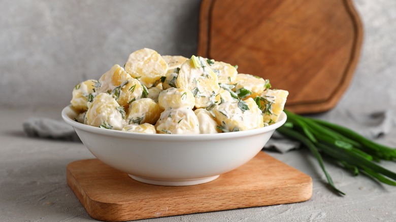 bowl of potato salad on wood block