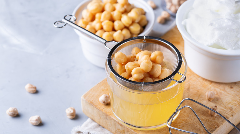 Aquafaba being strained from chickpeas.