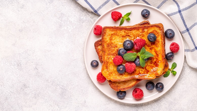 french toast and berries on white plate