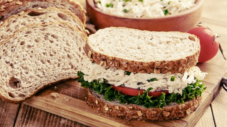 A chicken salad, lettuce, and tomato salad on multigrain bread